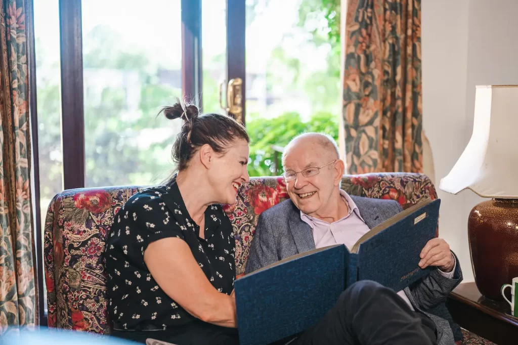 Two people looking at a photo album reminiscing